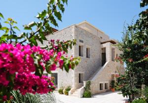 a building with pink flowers in front of it at Margo Beach Hotel in Gythio