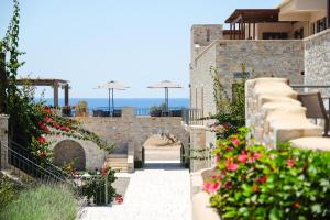 un patio con flores al lado de un edificio en Margo Beach Hotel, en Gythio