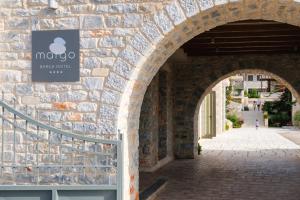 um arco com um sinal de maçã numa parede de tijolos em Margo Beach Hotel em Gythio