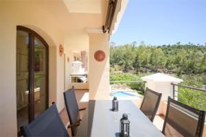 a view from the balcony of a house with a table and chairs at Los Arqueros Las Jacarandas in Benahavís