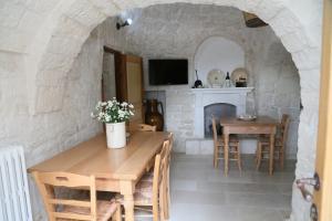 a kitchen and dining room with a stone wall at Trullo Montetrecarlini in Alberobello