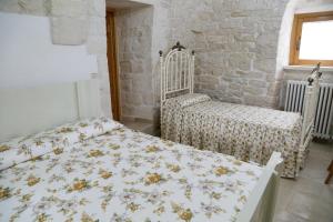 a bedroom with a bed and two chairs in it at Trullo Montetrecarlini in Alberobello