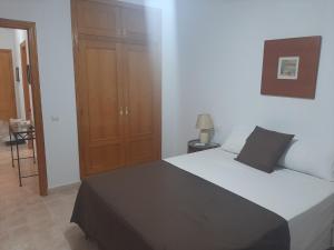 Un dormitorio con una cama y un armario de madera. en Primavera Sunshine, en Albir 11 fotos más