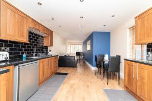 a kitchen with wooden cabinets and a dining room at The New Mill Apartments in Newcastle upon Tyne