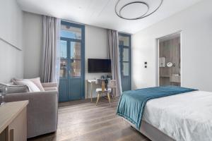 a bedroom with a bed and a couch and a desk at Hellenic Vibes Smart Hotel in Athens