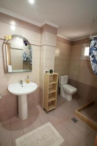 a bathroom with a sink and a toilet and a mirror at Santa Barbara Lakis Apartments in Perivolion +78 photos