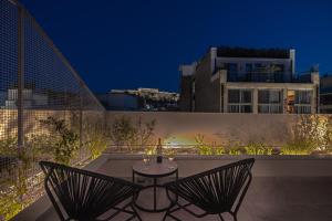Hellenic Vibes Smart Hotel في أثينا: فناء على كرسيين وطاولة على السطح