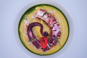 a plate of food with a letter g on it at Margo Beach Hotel in Gythio