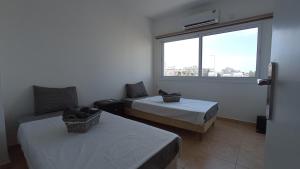a hotel room with two beds and a window at 5 min to the Beach Holiday Shared Apartment - private ROOM in 3 bdr Apt in Larnaka