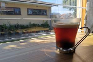 a glass of beer sitting on top of a table at Cozy, peaceful garden cottage in Cape Town