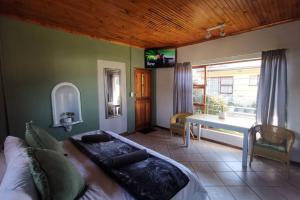 a bedroom with a large bed and a window at Cozy, peaceful garden cottage in Cape Town