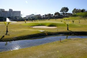 pole golfowe z zielenią i rzeką w obiekcie Apartamento El Remo w mieście Torremolinos