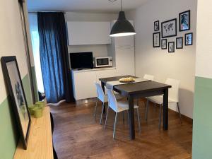 a dining room table and chairs in a room at Pinzolo Wellness Apartment in Pinzolo