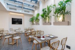 a room with tables and chairs and potted plants at Hellenic Vibes Smart Hotel in Athens