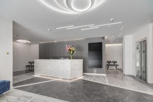 a lobby with a marble counter with a vase of flowers at Hellenic Vibes Smart Hotel in Athens