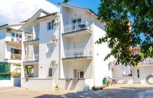 un edificio bianco con balconi e un albero di ADRIA a Trogir