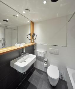 uma casa de banho com um lavatório, um WC e um espelho. em Best Western Hotel Trier City em Trier