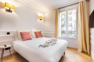 uma cama branca num quarto com uma janela em CMG Lafayette - Gare de l'Est em Paris