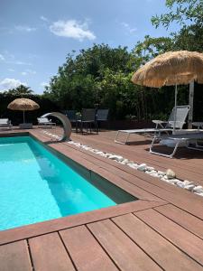 uma piscina com cadeiras e guarda-sóis num deque em Villa Playa San Juan em Soto de la Marina
