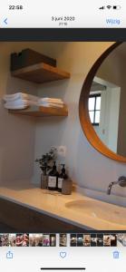 eine Badezimmertheke mit einem Spiegel und einem Waschbecken in der Unterkunft B&B Biesvenhof in Merksplas