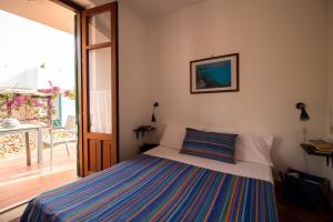 um quarto com uma cama e uma porta de vidro deslizante em Villa Dei Gabbiani em Favignana