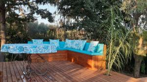un canapé bleu assis sur une terrasse en bois dans l'établissement Il Casale Del Sogno, à Ardea