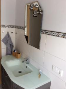 uma casa de banho com um lavatório e um espelho em Ferienwohnung A&K em Bottrop