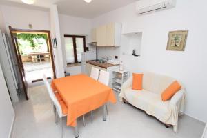 een keuken met een tafel en een bank en een tafel en stoelen bij Apartments Luna in Rovinj