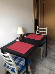 Una mesa negra con dos esteras rojas. en Ferienwohnung A&K, en Bottrop