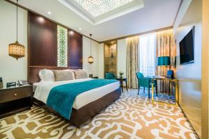 um quarto de hotel com uma cama, uma secretária e uma televisão em TIME Rako Hotel em Al Wakrah