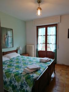 a bedroom with a bed with two towels on it at Locanda Belvedere Pey in Zerba