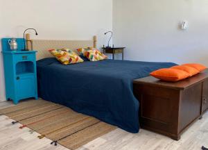 a bedroom with a blue bed with orange pillows at Countryside in Füle