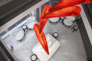 an overhead view of a room with white chairs and an orange sculpture at The Excelsior - Small Luxury Hotels of the World in Thessaloniki