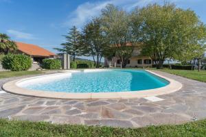 a swimming pool with a stone walkway around it at Agriturismo Bella Cima in Montefiascone
