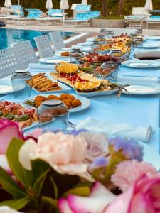 una mesa larga con platos de comida. en PRINCIPE DEL LAGO, en Shkodër