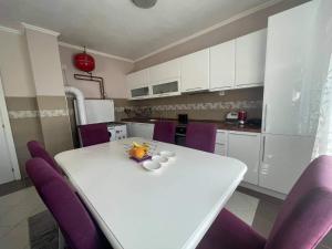 a kitchen with a white table and purple chairs at Guest house Paradise Kolašin in Kolašin +11 photos