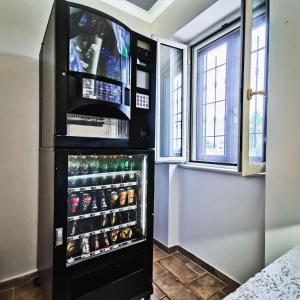 ein schwarzer Kühlschrank mit Gefrierfach in einem Zimmer mit Fenstern in der Unterkunft Il Sentiero di Leano in Terracina