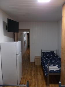 sypialnia z łóżkiem i białą lodówką w obiekcie Domek N5 - 2 Pokoje , Kuchnia , Łazienka 5 osobowy - FreezerHause Izdebno- NoclegiGrodziskPL w mieście Grodzisk Mazowiecki