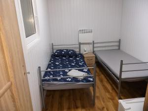 a small room with two beds and a window at Domek N5 - 2 Pokoje , Kuchnia , Łazienka 5 osobowy - FreezerHause Izdebno- NoclegiGrodziskPL in Grodzisk Mazowiecki