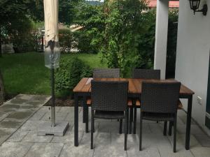 a wooden table with chairs and an umbrella at Ferienwohnung Gassner in Piding