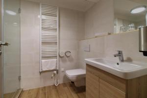 a bathroom with a sink and a toilet and a shower at Villa Marina Inn in Siófok