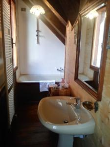 uma casa de banho com um lavatório e uma banheira em La finestra sulla contea em Ovaro