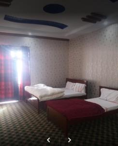 een kamer met 2 bedden in een kamer bij Happy Heart Hotel & Restaurant in Malam Jabba