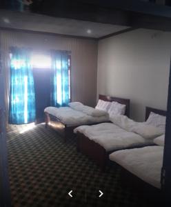een kamer met drie bedden in een kamer bij Happy Heart Hotel & Restaurant in Malam Jabba