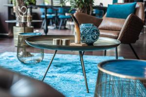 une table avec un vase sur un tapis bleu dans l'établissement Fletcher Hotel-Restaurant Arneville-Middelburg, à Middelbourg