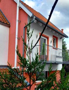 ein Gebäude mit einem Balkon und einem Baum davor in der Unterkunft Muemling Apartment 2 in Erbach