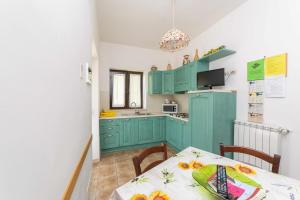 a kitchen with green cabinets and a table at Agriturismo Bella Cima in Montefiascone