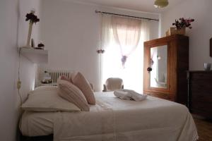 1 dormitorio con cama con espejo y ventana en La Residenza dei Nonni, en Montefranco