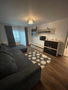 een woonkamer met een zwarte bank en een keuken bij Luxury House Medusa in Piteşti