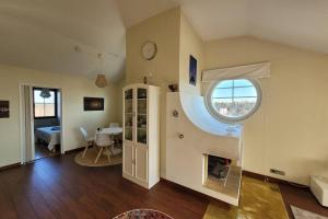 a living room with a fireplace and a room with a table at Golfapartment in Pickala in Siuntio